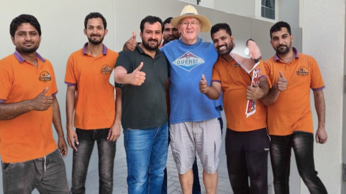 Smiling customer posing with Tiger Movers team after successful home relocation in Abu Dhabi