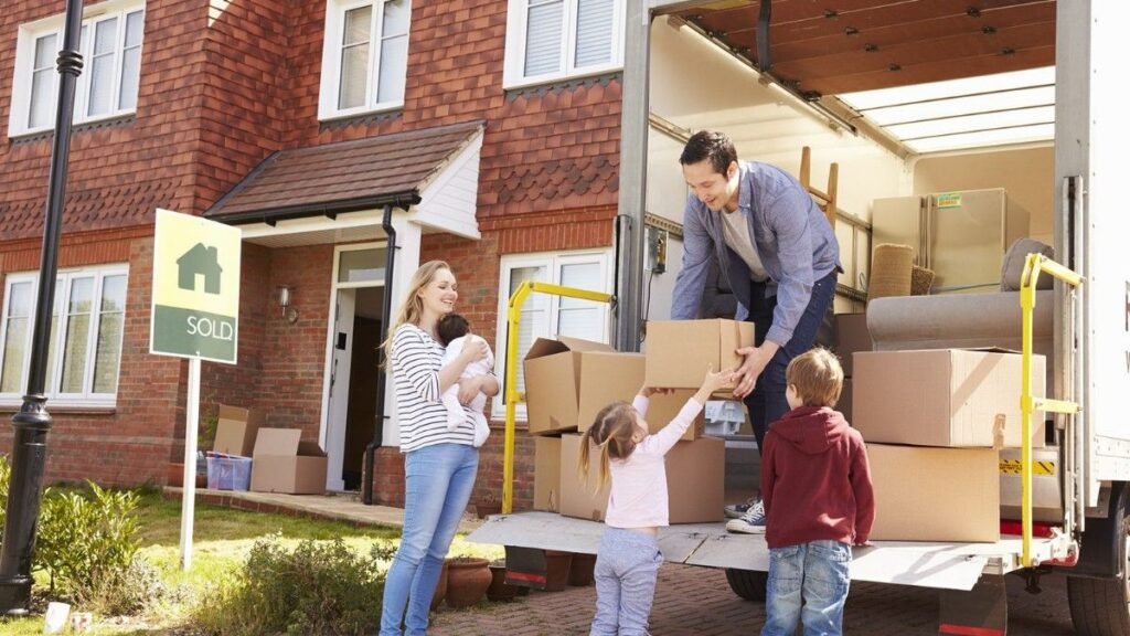 Movers wrapping furniture in a living room