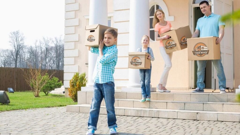 Happy family with moving boxes and Tiger Mover team